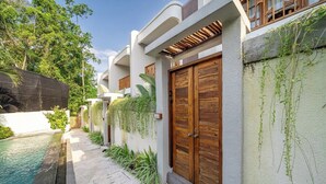 Un edificio moderno con piscina, porte in legno e un'area giardino.