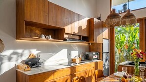 Una cucina moderna con mobili in legno, forno a microonde integrato e zona pranzo con tavolo apparecchiato per due.