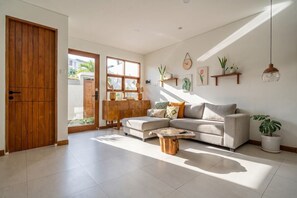 Un salón amplio con un sofá, una mesa de centro y un aparador de madera.