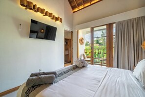 Une chambre d’hôtel avec un lit, un téléviseur à écran plat fixé au mur et un balcon avec des rideaux.
