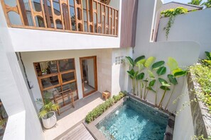 Un bâtiment à deux étages doté d’un balcon, d’une piscine et d’un petit espace patio.