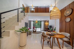 A modern interior with a staircase, a dining area, and a living space. - Cozy 1BR Flat in Ubud • Pool • Kitchen • Garden (Gianyar Regency)