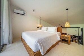 A bedroom with a bed, bedside tables, an air conditioning unit, and pendant lights. - Cozy 1BR Flat in Ubud • Pool • Kitchen • Garden (Gianyar Regency)
