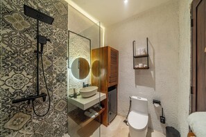 A modern bathroom with a glass-enclosed shower, a wooden vanity, and a toilet. - Cozy 1BR Flat in Ubud • Pool • Kitchen • Garden (Gianyar Regency)