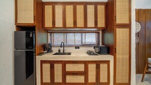 A compact kitchen with wooden cabinets, a refrigerator, a sink, and a microwave. - Chic 1BR in Tropical Ubud • Pool • Kitchen • Patio (Gianyar Regency)