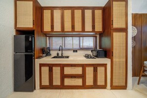 A compact kitchen with wooden cabinets, a refrigerator, a sink, and a microwave. - Chic 1BR in Tropical Ubud • Pool • Kitchen • Patio (Gianyar Regency)