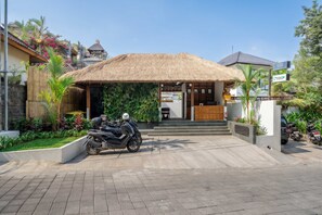 A building with a thatched roof entrance, a reception desk, and a motorcycle parked in front. - Best 1BR Stay in Ubud • Pool • Garden • Kitchen (Gianyar Regency)
