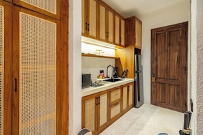 Eine Küche mit Holzschränken, einem Edelstahlkühlschrank und einer Spüle.