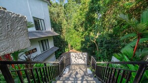 A staircase leading to a white building surrounded by lush greenery. - Designer 1BR Flat in Ubud w Pool, Garden & Kitchen (Gianyar Regency)