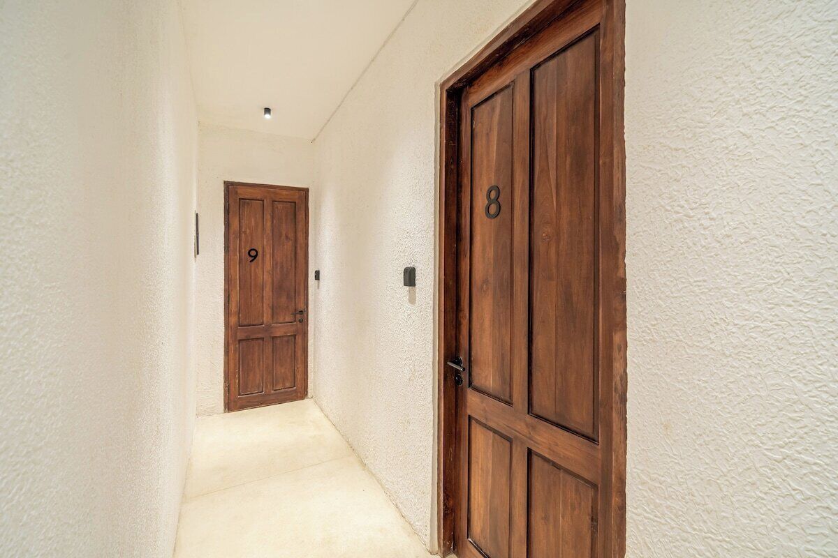 A hallway with two wooden doors, each marked with a number.