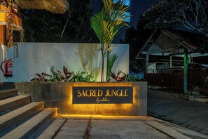A sign for 'Sacred Jungle' with a fire extinguisher mounted on a wall. - Designer 1BR Flat in Ubud w Pool, Garden & Kitchen (Gianyar Regency)