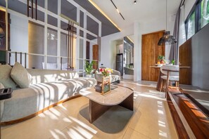 A modern living room with a sofa, coffee table, and a dining area with a table and chairs. - Cozy 1BR in Central Ubud • Pool • Patio • Kitchen (Ubud)