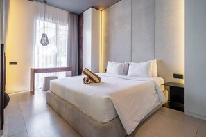 A modern hotel room with a large bed, a bedside table, a nightstand, and a window with curtains. - Cozy 1BR in Central Ubud • Pool • Patio • Kitchen (Ubud)