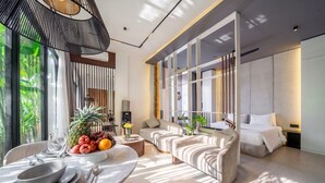 Uma sala de estar moderna com sofá, uma mesa de jantar com uma cesta de frutas e uma cama com vista.