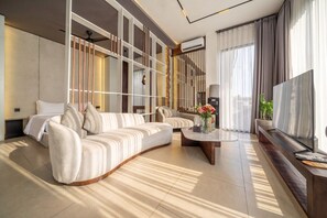 A modern living room with a sofa, a coffee table, and a TV. - Best Ubud's 1BR w Pool, Patio & Private Kitchen (Kabupaten Gianyar)