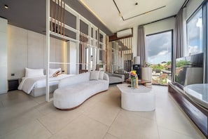 Ein modernes Hotelzimmer mit Bett, Sofa und rundem Couchtisch.