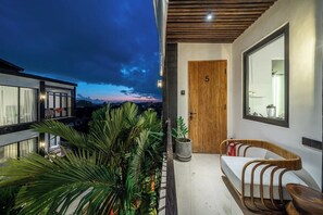 A modern balcony with a wooden door marked '5', a cushioned bench, and potted plants. - Best Ubud's 1BR Apartment w Pool, Patio & Kitchen (Ubud)
