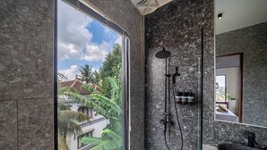 Un baño moderno con un gran ventanal, una ducha e un lavamanos.
