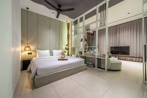 A modern bedroom with a large bed, a ceiling fan, a TV, and a seating area. - Modern 1BR Flat in Ubud w Pool, Patio & Kitchen (Kabupaten Gianyar)