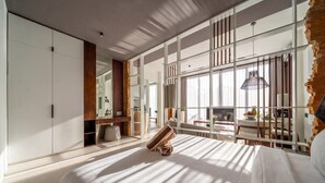 Un dormitorio moderno con una cama grande, un armario, un escritorio y vistas al exterior.
