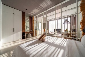 A modern bedroom with a large bed, a wardrobe, a desk, and a view of the outdoors. - Serene 1BR Stay in Ubud w Pool & Private Kitchen (Ubud)