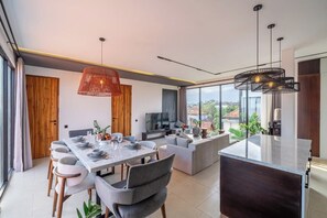Cozinha moderna com área de refeições, grandes janelas e vista para o exterior.
