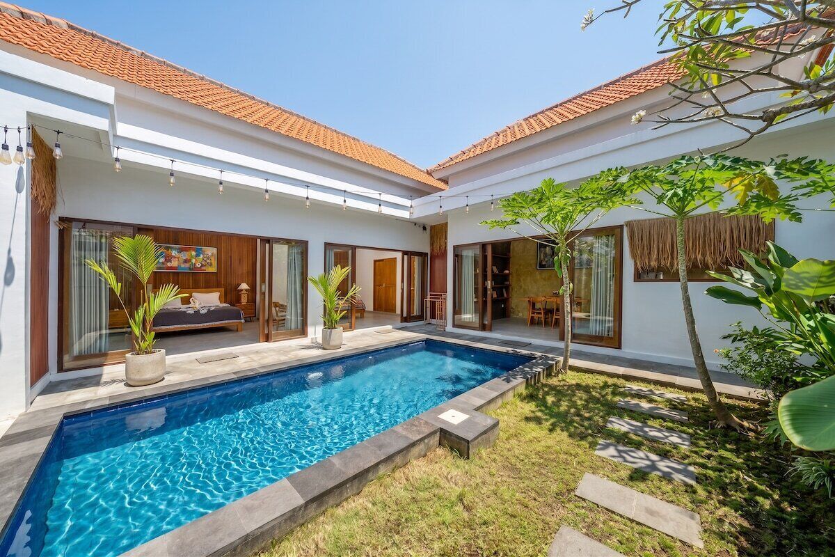 Ein modernes Haus mit Swimmingpool, großen Fenstern und einem gepflegten Garten.