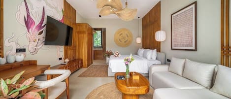 Un salon moderne doté d’un téléviseur à écran plat, d’un canapé, d’une table basse et d’un coin repas avec une table et des chaises en bois.