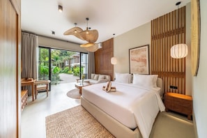 A modern bedroom with a large bed, a desk, and a view of greenery outside. - Serene 1BR • Ubud • Pool • Private Kitchen & Patio (Gianyar Regency)