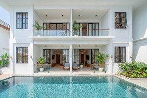 A two-story building with a swimming pool, balconies, and potted plants. - Serene 1BR • Ubud • Pool • Private Kitchen & Patio (Gianyar Regency)