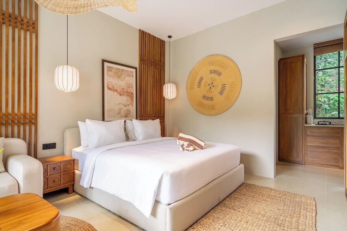 Une chambre moderne avec un grand lit, des tables de chevet, une horloge murale et une fenêtre donnant sur un beau paysage.