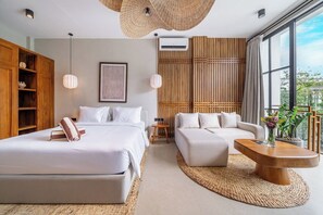A modern hotel room with a large bed, a sofa, a coffee table, and a view of the outdoors. - Luxe 1BR in Ubud w Pool, Private Kitchen & Balcony (Gianyar Regency)