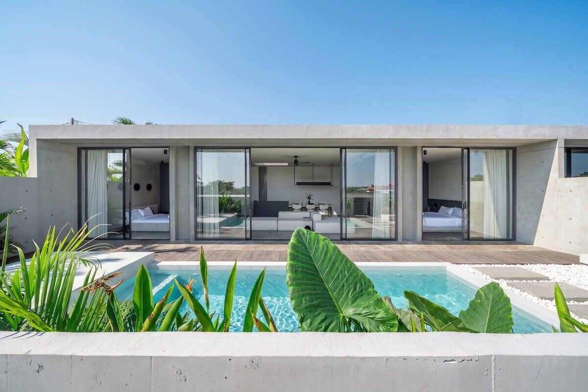 Una casa moderna con piscina, amplios ventanales y un interior minimalista.