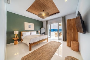 Une chambre moderne dotée d’un grand lit, d’un plafond en bois, d’un téléviseur à écran plat et offrant une vue sur l’extérieur.