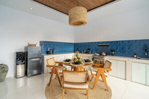 Une cuisine moderne dotée d’un îlot central, d’appareils électroménagers en acier inoxydable et d’un revêtement mural bleu.