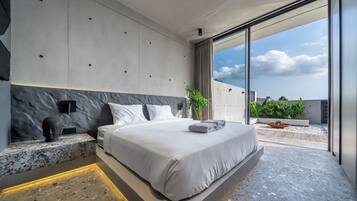 A modern bedroom with a large bed, a marble headboard, and a view of the sky through a sliding glass door.