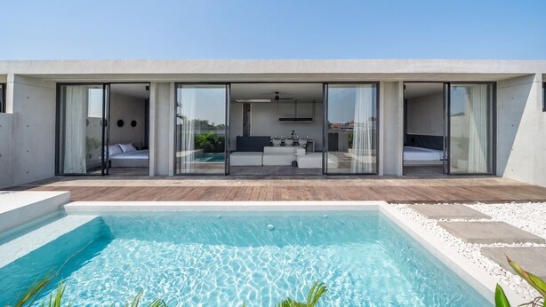 Ein modernes Haus mit Swimmingpool, großen Glasfenstern und einem minimalistischen Innenraum.