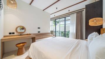 A modern bedroom with a large bed, a wooden bedside table, a round mirror, and a hanging light fixture.