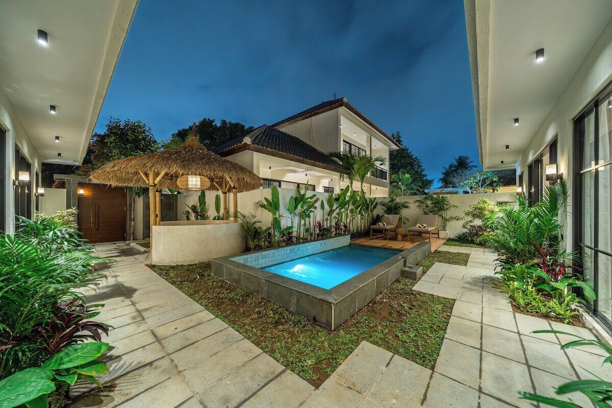A modern house with a swimming pool, surrounded by a garden with various plants.