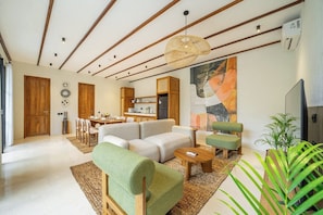 A modern living room with a sofa, chairs, a coffee table, and a dining area with a table and chairs. - Designer 3BR Villa in Ubud w Pool, Patio & Garden (Gianyar Regency)