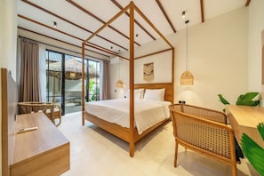 A bedroom with a four-poster bed, a wooden desk, a wicker chair, and a hanging light fixture. - Designer 3BR Villa in Ubud w Pool, Patio & Garden (Gianyar Regency)