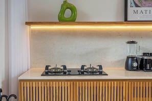 A kitchen with a gas stove, a blender, and a green decorative item on the countertop. - Tropical 3BR Villa in Ubud w Pool, Patio & Garden (Gianyar Regency)