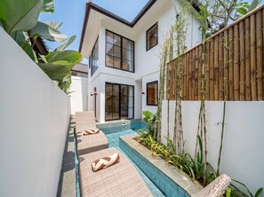 A modern house with a swimming pool, outdoor seating, and a bamboo fence. - Cozy 1BR Villa in Lush Ubud w Pool, Patio & Garden (Gianyar Regency)
