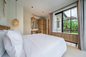 A bedroom with a large bed, a wooden wardrobe, a desk, and a window with curtains. - Cozy 1BR Villa in Lush Ubud w Pool, Patio & Garden (Gianyar Regency)