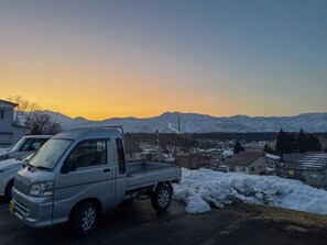 A parked pickup truck in a residential area with houses and mountains in the background.