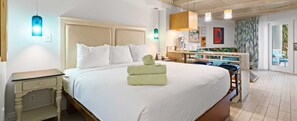 A hotel room with a large bed, bedside tables, a desk, and a view of the outside. - Margaritaville Vacation Club - St. Thomas USVI Luxury Wyndham Presidential Suite (St. Thomas)