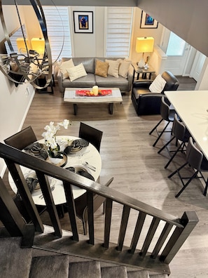 A modern living room with a sofa, coffee table, and dining area. - Free Car garage|3BR|YYC|Banff|Canmore|Winsport|Stampede (Calgary)