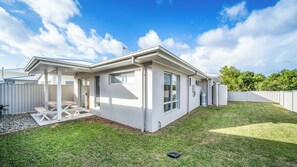 A single-story house with a covered patio, a large water tank, and a fenced backyard. - Tuckeroo Retreat -Peaceful home in Mullumbimby - views of Mt Chincogan (Mullumbimby)