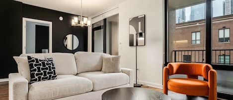 A modern living room with a sofa, a coffee table, a floor lamp, and a chair.