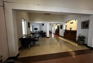 A spacious interior with a dining area, kitchen, and a reception desk. - Casa D'ladera Bandung Double Suite (Bandung)